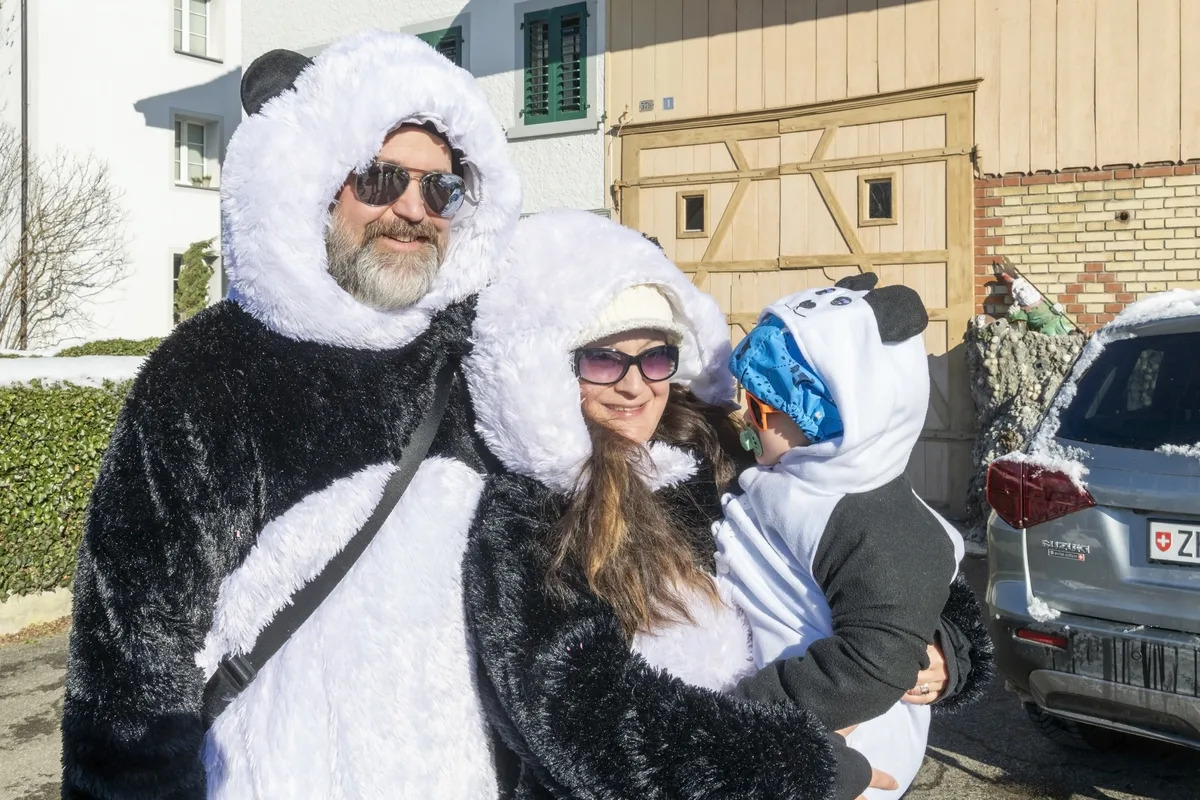 Papa- und Mamabär sind altgediente Eulach Schränzer aus Winterthur. Sie möchten dem Babybär die Fasnacht näher bringen. Eine Familie lächelt glücklich in die Kamera.
